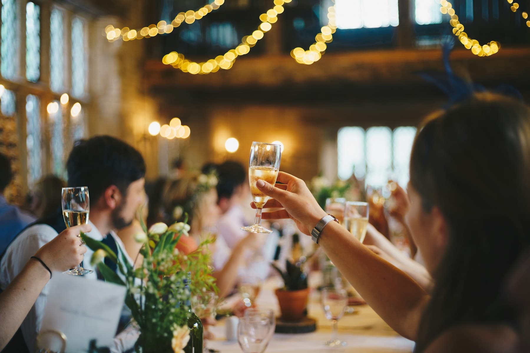 Guests raising their glasses around a warmly lit reception table